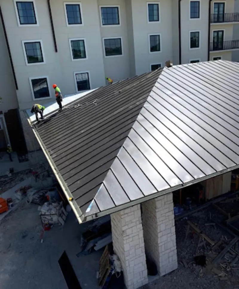 Crew installing standing seam metal roof panels on a commercial project in Half Moon Bay